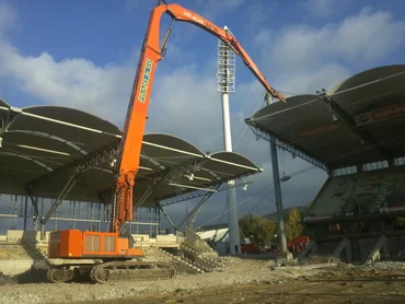 Foto: Gerhard-Hanappi-Stadion Wien: Bagger mit einem extrem hohen Greifarm inmitten eines teilweise bereits abgebrochenen Stadions