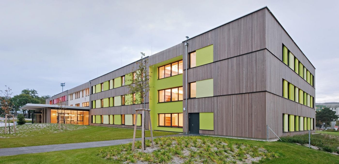 Foto: Pflegeheim Horn: Außenansicht des dreistöckigen Gebäudes mit Holzfassade, davor eine Grünfläche