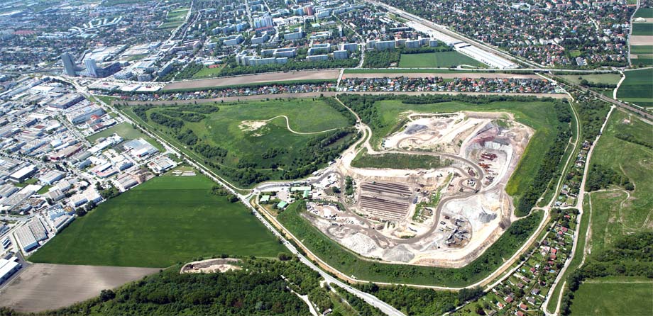 Photo: Aerial view of a landfill site surrounded by grasslands and the beginnings of an urban area.